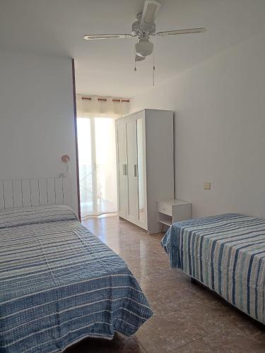 a bedroom with two beds and a ceiling fan at Relax on Miramar Beach in Miramar