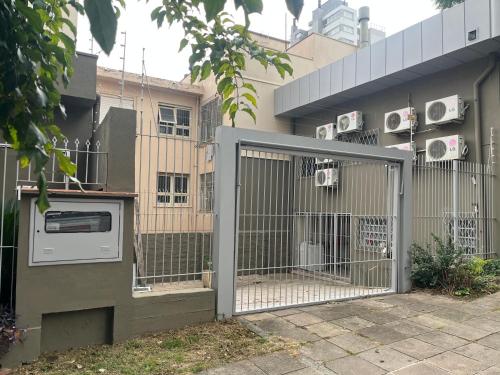 a fence in front of a building with a microwave at Casa para 9 pessoas perto da Dom Pedro 2 in Porto Alegre