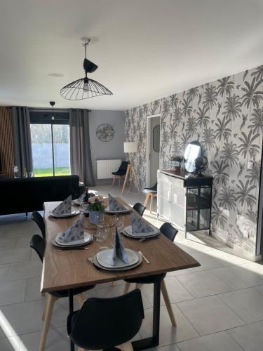 un salon avec une table et des chaises en bois dans l'établissement La Villa Maxence, à Crasville-la-Mallet