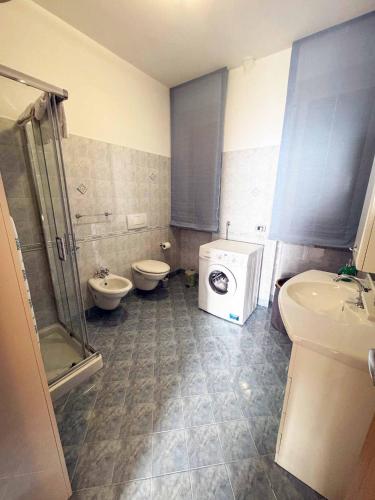 a bathroom with a toilet sink and a washing machine at Ambra Holiday House in Furore