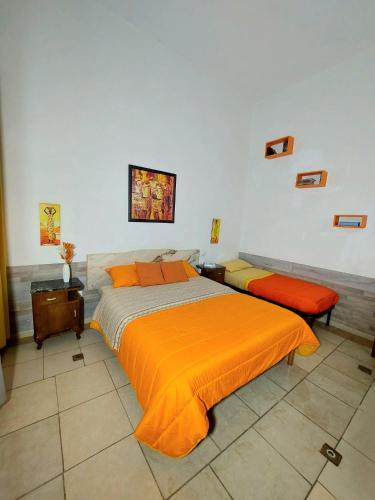 a bedroom with two beds with orange comforters at B&B Cappotto civico 48 in Pompei