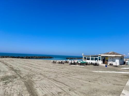 a building on the beach with tables and chairs at Casa Romano SeaFront in Fiumicino
