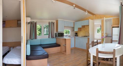 une cuisine et un salon avec une table et une salle à manger dans l'établissement Domaine de la Caille, à La Balme-de-Sillingy