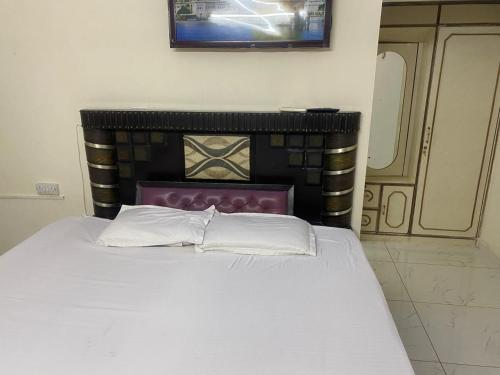 Un dormitorio con una cama con cabecero negro. en 2 BDRM APARTMENT with Kitchen and AC, Parking, en Sohāna