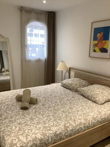 - un lit avec deux oreillers et un chapeau dans l'établissement Appartement lumineux, à Calvi