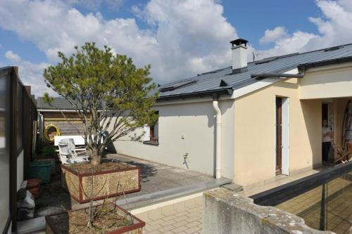 une maison blanche avec un arbre dans une cour dans l'établissement L'Alizée - Terrace overlooking the lake, à Aix-les-Bains