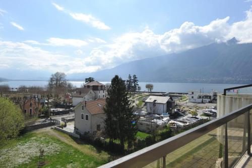 une vue d'une ville avec une montagne en arrière-plan dans l'établissement L'Alizée - Terrace overlooking the lake, à Aix-les-Bains