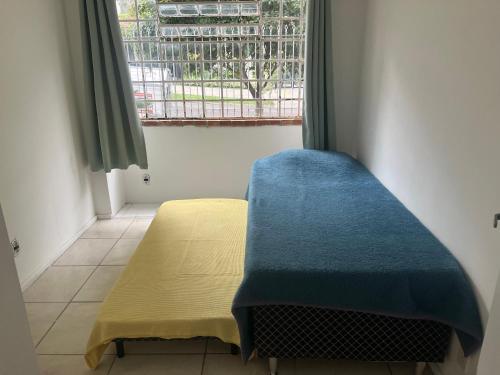a small room with a bed and a window at Casa para 9 pessoas perto da Dom Pedro 2 in Porto Alegre