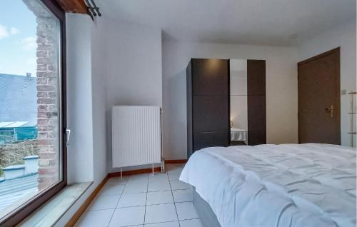 a bedroom with a bed and a large window at 2 Bedroom Pet Friendly Home In Treignes in Treignes