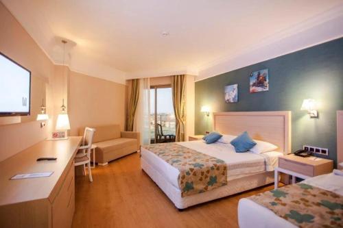 a hotel room with two beds and a desk at Linda Sunny Beach Hotel & Spa-Ultra All Inclusive in Side