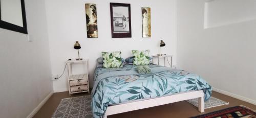 a bedroom with a bed with a blue comforter at Hermanus Backpackers & Budget Accommodation in Hermanus