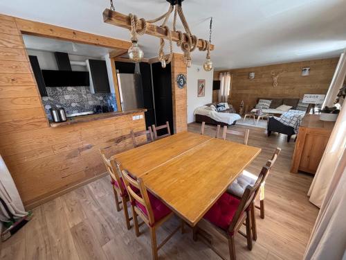 une salle à manger avec une table et des chaises en bois dans l'établissement le petit sport 2, à La Salle Les Alpes