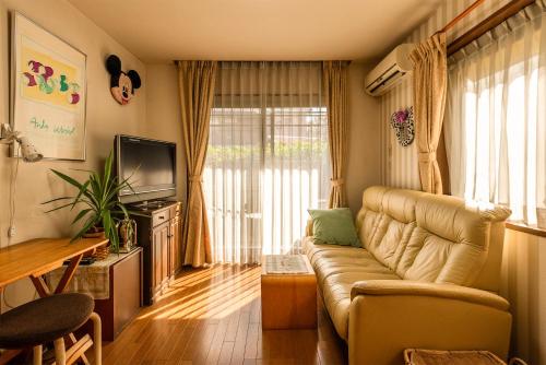 a living room with a couch and a television at GP House in Tokyo