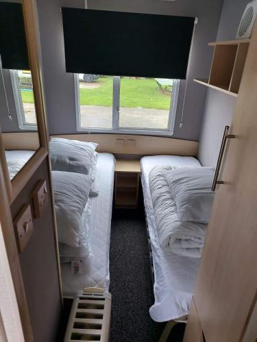 a small room with two beds and a window at Caravan getaway sand le mere tunstall in Hull