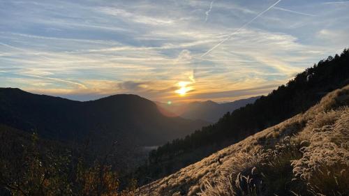 a view of the sun setting over a mountain range at Les 3 flocons in La Colmiane