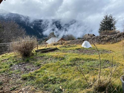 a field of grass with a fence and a mountain at Les 3 flocons in La Colmiane