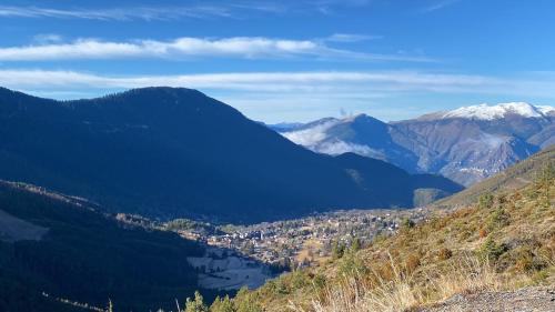 a view of a valley in the mountains with a city at Les 3 flocons in La Colmiane