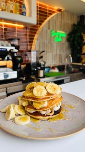 a stack of pancakes with bananas on a plate at Eleni Rooms in Parikia