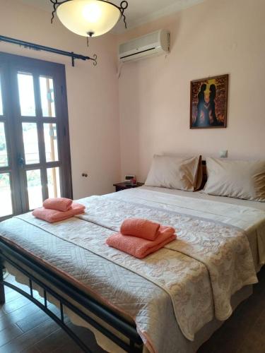 a bedroom with a large bed with two pillows on it at TOBY's HOUSE in Poseidónion