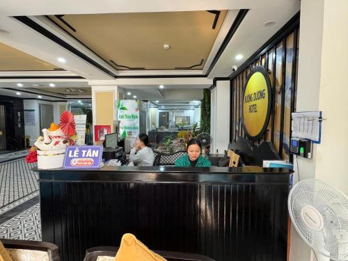 two women sitting at the counter of a restaurant at Sunflower Hotel by Huong Duong Hotel - Thanh Hoa in Thanh Hóa