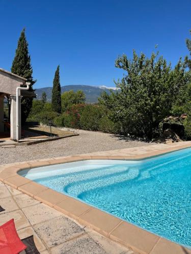 une piscine au milieu d'une cour dans l'établissement Jolie maison avec piscine et vue sur le Mont Ventoux, à Mormoiron
