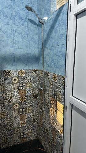 a bathroom with a shower with a glass door at TAMOUNT Surf House in Agadir