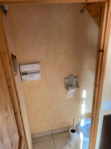 une salle de bain avec un lavabo et un distributeur de papier toilette dans l'établissement Planchette, à Savigné-lʼÉvêque