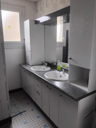 a white bathroom with two sinks and a window at Bienvenue au gite papillon in Sainte-Verge