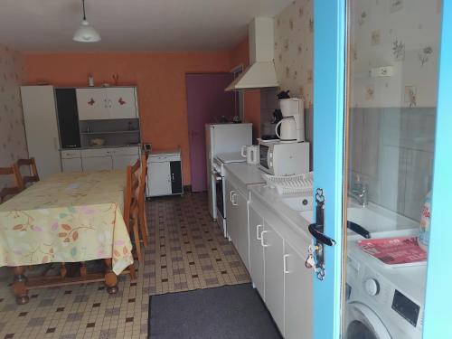 a kitchen with a table and a kitchen with a sink at Bienvenue au gite papillon in Sainte-Verge