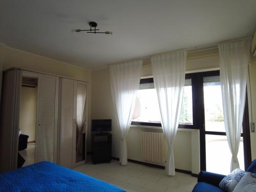 a bedroom with white curtains and a bed and a window at Casa Bellavista in Termoli