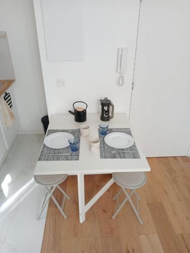 une table blanche avec deux casseroles au-dessus dans l'établissement Charming Studio in the Heart of Nice, à Nice