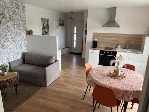 une cuisine et un salon avec une table et un canapé dans l'établissement Maison de campagne proche 24h, à Roézé-sur-Sarthe