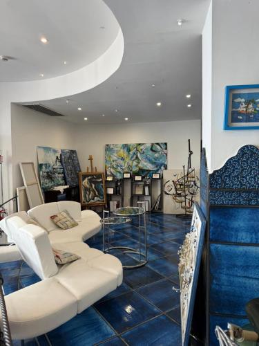 a room with couches and paintings on the walls at Positano Art Hotel Pasitea in Positano