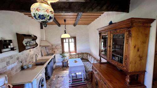 a kitchen with a counter and a table in a room at Casa Maramureșeană - Refugiu Tradițional Maramureșean Cazare de Poveste în Natură lângă pârâu Loc de joaca pentru Copii Parcare Foișor in Marga