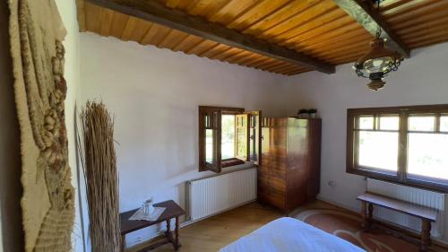 a room with a bed and two windows in it at Casa Maramureșeană - Refugiu Tradițional Maramureșean Cazare de Poveste în Natură lângă pârâu Loc de joaca pentru Copii Parcare Foișor in Marga