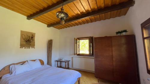 a bedroom with a bed and a window at Casa Maramureșeană - Refugiu Tradițional Maramureșean Cazare de Poveste în Natură lângă pârâu Loc de joaca pentru Copii Parcare Foișor in Marga
