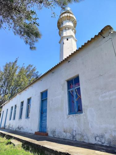 a lighthouse on top of a white building at Machalele's House - Casa T2 acolhedora para casais e famílias na Ilha de Inhaca in Portinho da Inhaca