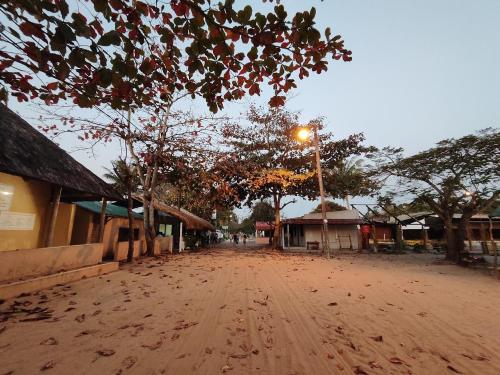 a dirt road in a town with a street light at Machalele's House - Casa T2 acolhedora para casais e famílias na Ilha de Inhaca in Portinho da Inhaca