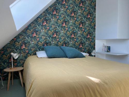 - une chambre avec un grand lit et du papier peint floral dans l'établissement Appartement T2 en pleine nature au sein d'une ferme au carré, à Wambrechies