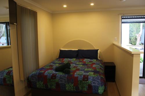 Un pat sau paturi într-o cameră la Acclaim Kingsway Tourist Park