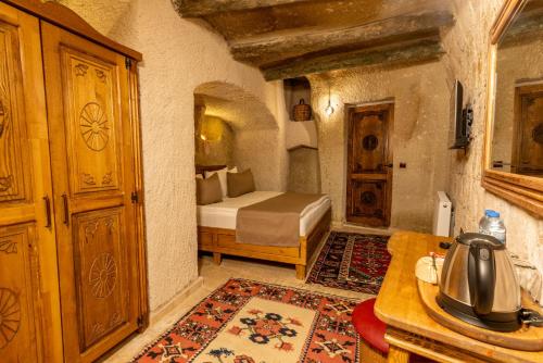 Un dormitorio con una cama y una mesa en una habitación. en Arkelas Cave House, en Göreme