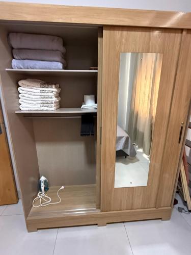 a wooden cabinet with a mirror in a room at Condomínio Bela Vista - Casa 11B in Campo Novo do Parecis
