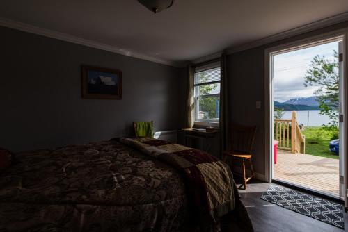 a bedroom with a bed and a large window at Out East B&B - Norris Point in Norris Point