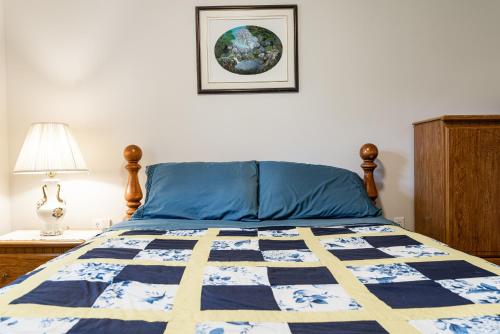 a bedroom with a bed with a blue and yellow quilt at Out East B&B - Norris Point in Norris Point