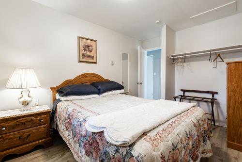 a bedroom with a large bed and a lamp and a dresser at Out East B&B - Norris Point in Norris Point