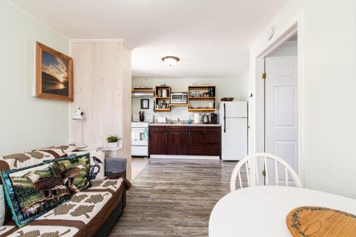 a living room with a couch and a kitchen at Out East B&B - Norris Point in Norris Point