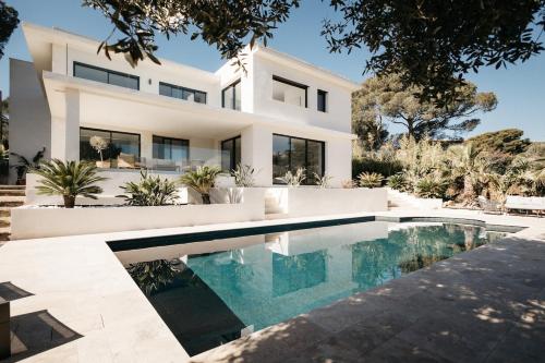 une maison blanche avec une piscine devant dans l'établissement Villa 328, à Saint-Raphaël