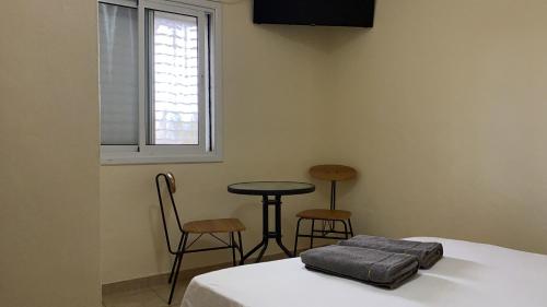 a room with a bed and a table and chairs at Guest house Циммер Дора, Мертвое море in Neve Zohar