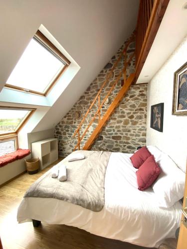 une chambre avec un grand lit blanc avec des oreillers rouges dans l'établissement Le cottage de Zoé, au Vivier-sur-Mer