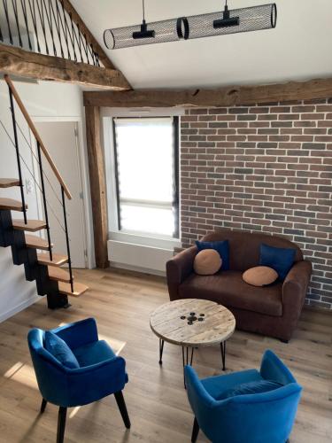 a living room with a couch and chairs and a table at Grange rénovée au calme entre Rennes et Saint Malo in Vignoc